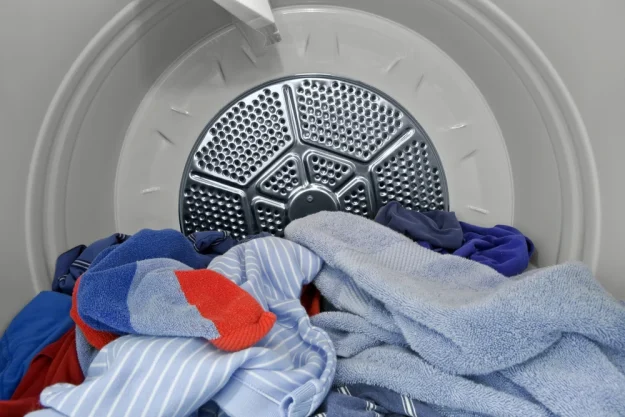 DepAppliance repair technician fixing a tumble dryer in a Birmingham household Appliance repair technician fixing a tumble dryer in a Birmingham household